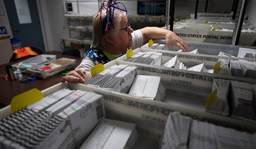Election worker Wendy Wimer looks through vote-by-mail ballots for the presidential primary election, March 12, 2024, at the Clark County Elections Office in Vancouver, Wash. (AP Photo/Jenny Kane, File)