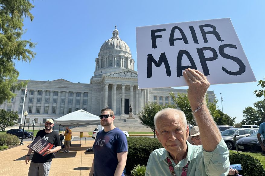 This photo taken with a smartphone shows Steve Perry, of Kansas City, holding a sign in opposition to Missouri’s congressional redistricting plan on Wednesday, Sept. 2, 2026, outside the state Capitol, in Jefferson City, Mo. (AP Photo/David A. Lieb)