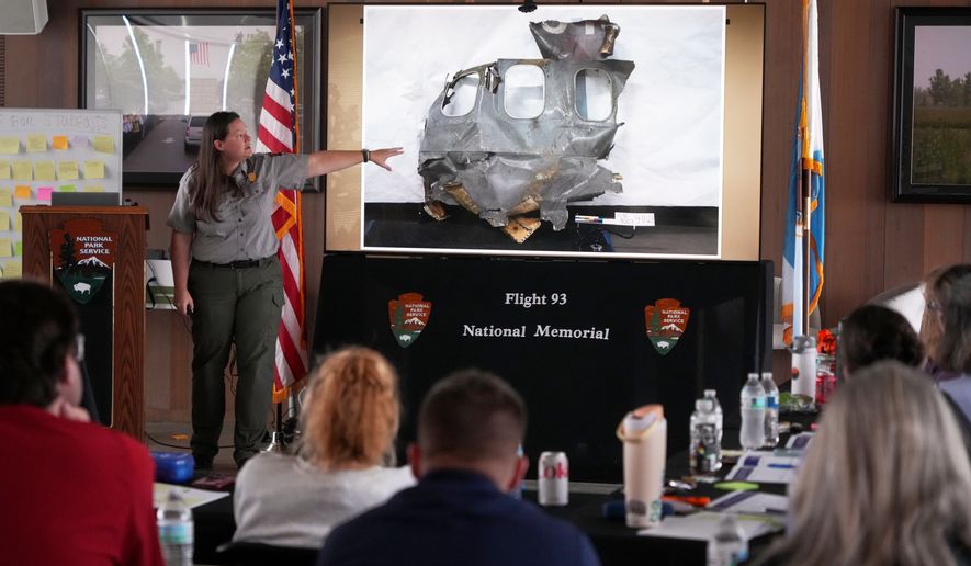 U.S. Park Ranger Betsy Keene, curator of National Parks of Western Pennsylvania, explains a slide showing a damaged part of United Flight 93 during an educators seminar at the Flight 93 National Memorial in Shanksville, Pa., Tuesday, June 23, 2026. (AP Photo/Gene J. Puskar)