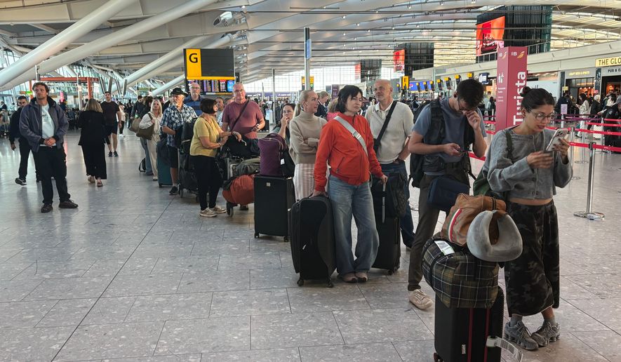 Passengers wait in line at Heathrow Airport in London, during an air traffic control problem that disrupted travel across Britain. (Jonathan Brady/PA via AP)