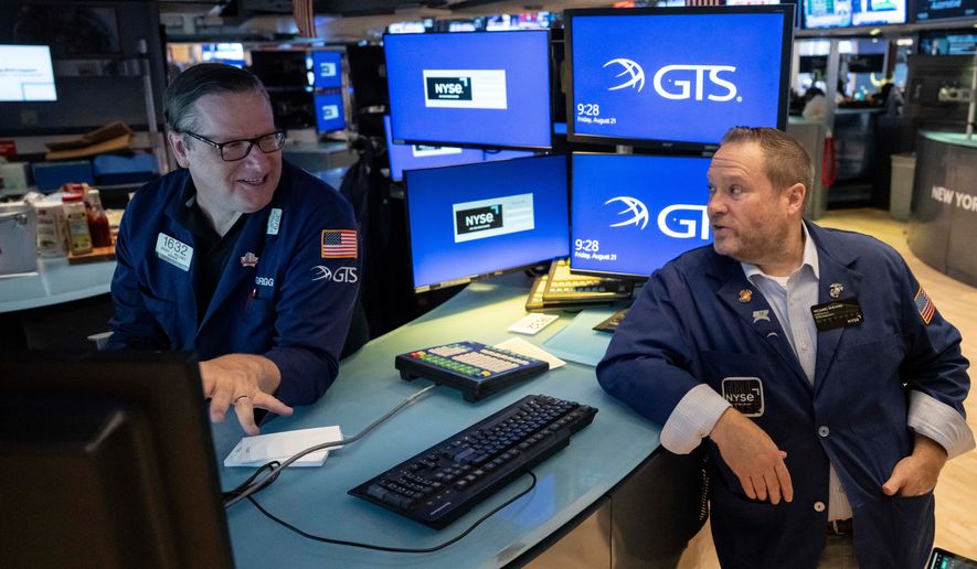Specialists Gregg Maloney, left, and Michael Shearin work on the floor of the New York Stock Exchange in New York, Friday, Aug. 21, 2026. (AP Photo/Yuki Iwamura)