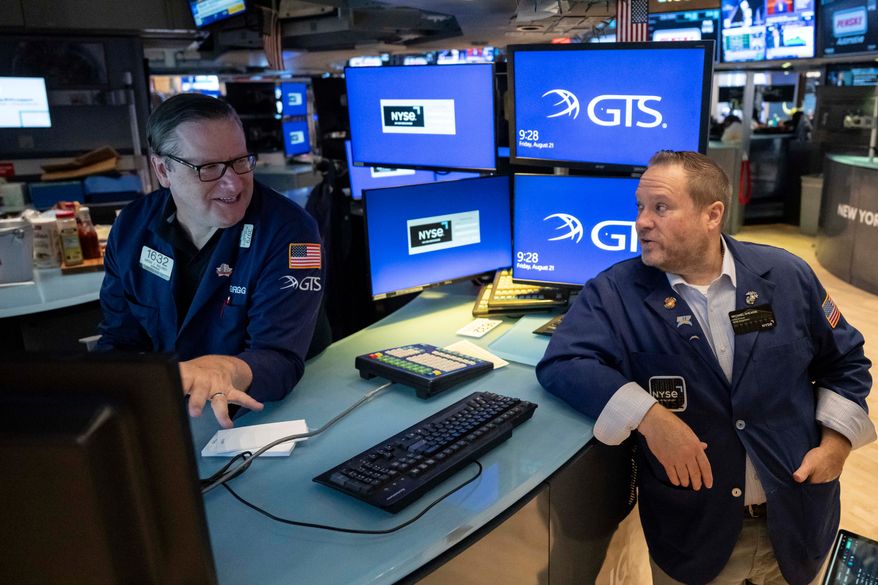 Specialists Gregg Maloney, left, and Michael Shearin work on the floor of the New York Stock Exchange in New York, Friday, Aug. 21, 2026. (AP Photo/Yuki Iwamura)
