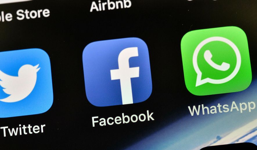 FILE - In this Thursday, Nov. 15, 2018 file photo the icons of Facebook and WhatsApp are pictured on an iPhone in Gelsenkirchen, Germany. (AP Photo/Martin Meissner,File)