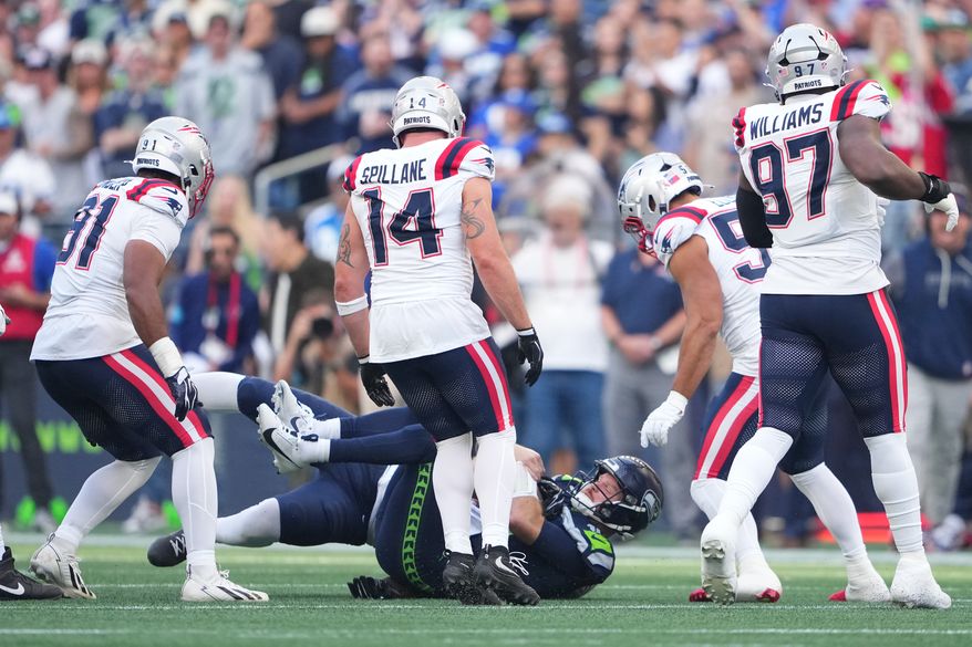 Seattle Seahawks quarterback Sam Darnold, down center, is sacked by New England Patriots linebacker Dre'mont Jones, behind, as New England Patriots linebacker Elijah Ponder (91), linebacker Robert Spillane (14), linebacker Christian Elliss (53), and defensive tackle Milton Williams (97) look on during the first half an NFL football game , Wednesday, Sept. 9, 2026, in Seattle. (AP Photo/Lindsey Wasson)