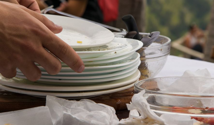 Stacking dirty plates at a restaurant after you finish a meal might reveal more about your childhood than you realize. (Photo by 682A IA on Shutterstock)