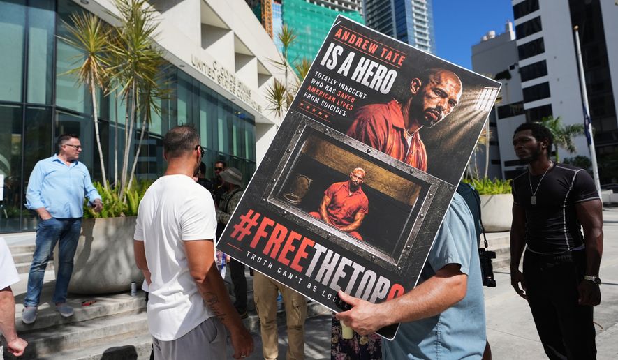 Supporters of Andrew and Tristan Tate stand outside of the C. Clyde Atkins U.S. Courthouse as they fight extradition to the United Kingdom on charges of rape and sex trafficking at a bond hearing, Thursday, Aug. 27, 2026, in Miami. (AP Photo/Lynne Sladky)