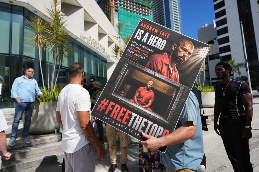 Supporters of Andrew and Tristan Tate stand outside of the C. Clyde Atkins U.S. Courthouse as they fight extradition to the United Kingdom on charges of rape and sex trafficking at a bond hearing, Thursday, Aug. 27, 2026, in Miami. (AP Photo/Lynne Sladky)