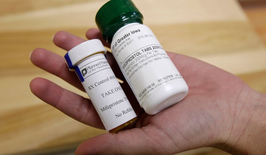 FILE - Bottles of abortion pills mifepristone, left, and misoprostol, right, are displayed at a clinic in Des Moines, Iowa, Sept. 22, 2010. (AP Photo/Charlie Neibergall, File)