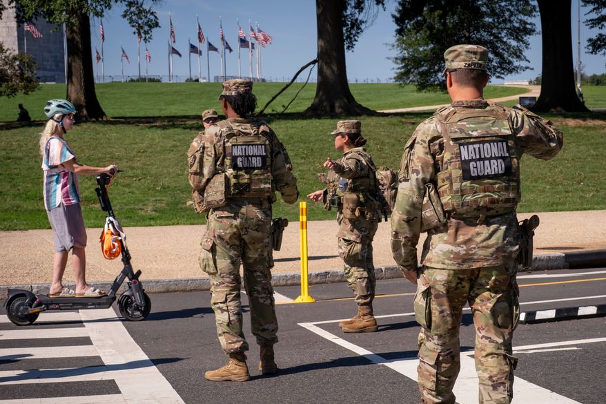 National Guard troops stop a young woman on a rental scooter near a closed intersection where President Donald Trump was holding an event, in Washington, Tuesday, Sept. 8, 2026. (AP Photo/J. Scott Applewhite)