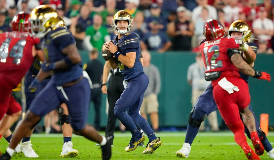 Notre Dame quarterback CJ Carr, center, drops back to pass during the second half of an NCAA college football game against Wisconsin Sunday, Sept. 6, 2026, in Green Bay, Wis. (AP Photo/Kayla Wolf)