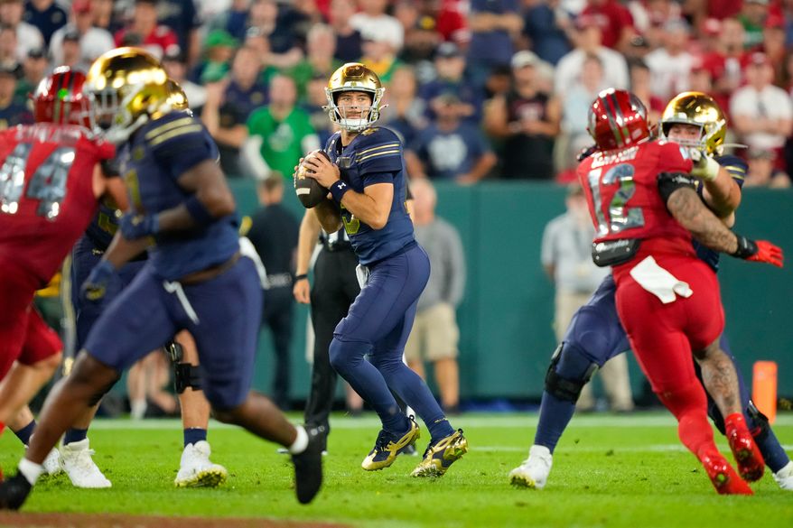 Notre Dame quarterback CJ Carr, center, drops back to pass during the second half of an NCAA college football game against Wisconsin Sunday, Sept. 6, 2026, in Green Bay, Wis. (AP Photo/Kayla Wolf)