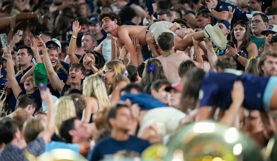 Notre Dame fans celebrate scoring a touchdown with pushups during the second half of an NCAA college football game against Wisconsin Sunday, Sept. 6, 2026, in Green Bay, Wis. (AP Photo/Kayla Wolf)