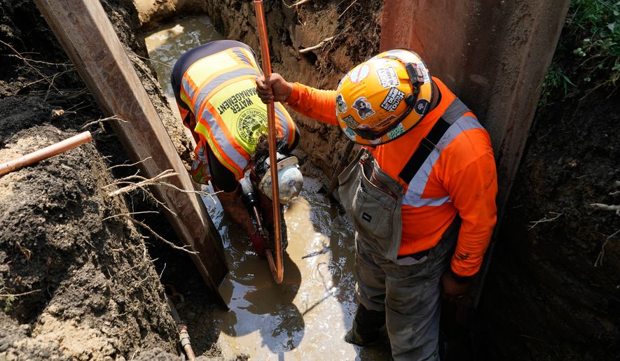 Workers install a copper pipe to replace a lead service line that brings drinking water to homes Tuesday, July 21, 2026, in Chicago. (AP Photo/Alyssa Goodman)