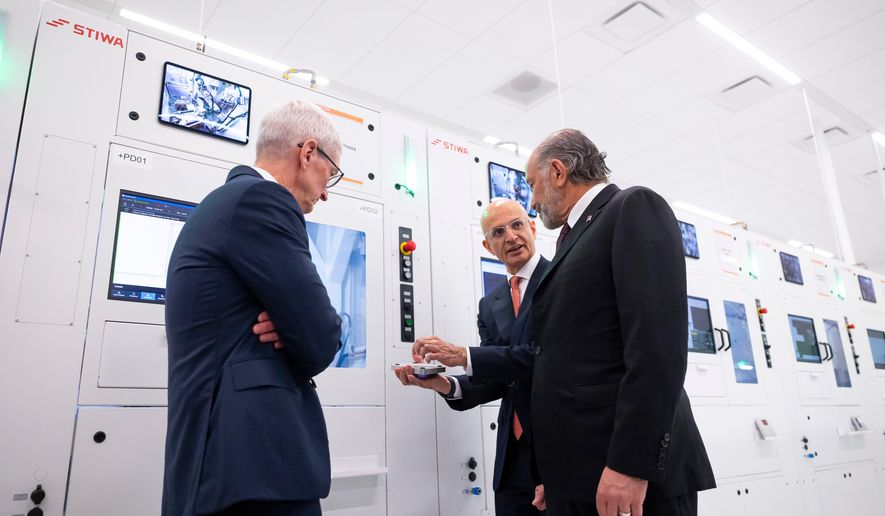 Apple COO Sabih Khan, center, and then-CEO Tim Cook, left, give U.S. Secretary of Commerce Howard Lutnick a tour of a learning lab at Apple's Advanced Manufacturing Center in Houston, Thursday, Aug. 13, 2026. (AP Photo/Annie Mulligan) ** FILE **