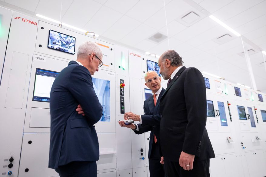 Apple COO Sabih Khan, center, and then-CEO Tim Cook, left, give U.S. Secretary of Commerce Howard Lutnick a tour of a learning lab at Apple's Advanced Manufacturing Center in Houston, Thursday, Aug. 13, 2026. (AP Photo/Annie Mulligan) ** FILE **