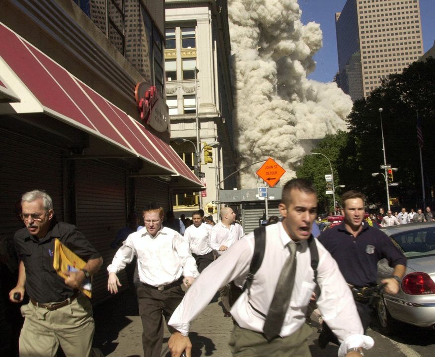 People run from the collapse of the World Trade Center towers, Sept. 11, 2001, in New York. (AP Photo/Suzanne Plunkett, File)