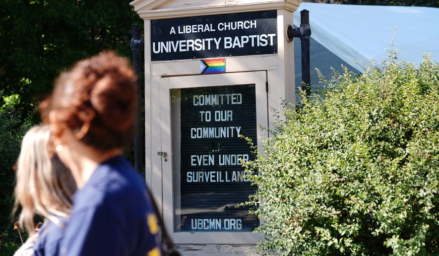 People walk by a sign outside University Baptist Church, Friday, Sept. 4, 2026, in Minneapolis. (AP Photo/Ellen Schmidt)