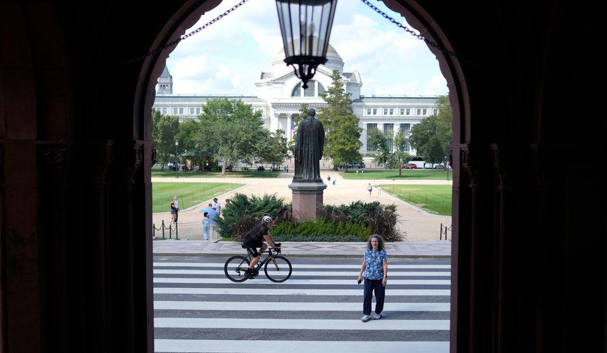 FILE - People are seen near the main entrance to the Smithsonian Institution Building, more commonly known as the Smithsonian Castle, which is closed for renovations, in Washington, Tuesday, Sept. 8, 2026. (AP Photo/Pablo Martinez Monsivais,FIle)
