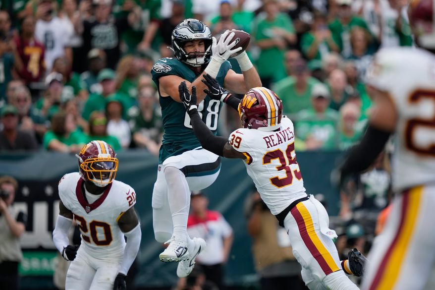 Philadelphia Eagles tight end Dallas Goedert (88) catches a pass over Washington Commanders safety Jeremy Reaves (39) for a touchdown during the first half of an NFL football game, Sunday, Sept. 13, 2026, in Philadelphia. (AP Photo/Matt Slocum)