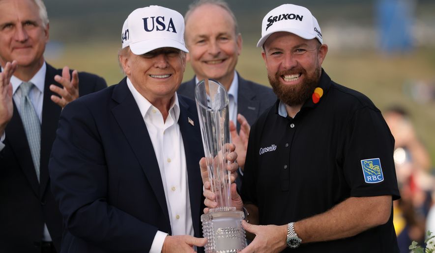 U.S. President Donald Trump presents the trophy to Irish Open golf winner Shane Lowry of Ireland whilst Ireland's Prime Minister Micheal Martin, center rear, looks on, at the Trump International Golf Links course in Doonbeg, Ireland, Sunday, Sept. 13, 2026. (AP Photo/Peter Morrison)