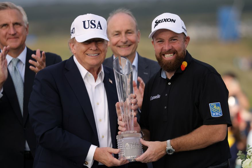 U.S. President Donald Trump presents the trophy to Irish Open golf winner Shane Lowry of Ireland whilst Ireland's Prime Minister Micheal Martin, center rear, looks on, at the Trump International Golf Links course in Doonbeg, Ireland, Sunday, Sept. 13, 2026. (AP Photo/Peter Morrison)