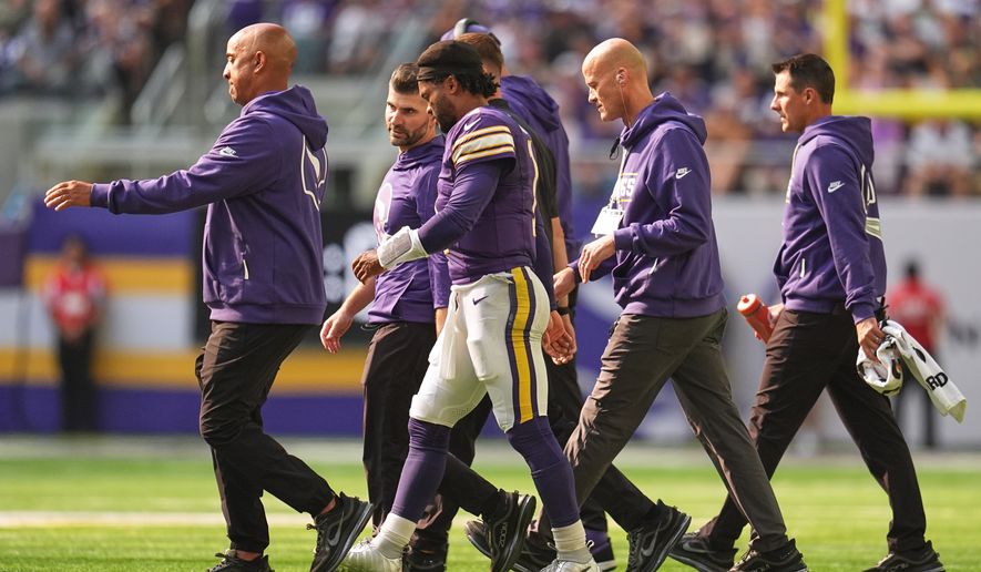 Minnesota Vikings quarterback Kyler Murray, center, walks off the field with staff after suffering an unknown injury during the first half of an NFL football game against the Green Bay Packers Sunday, Sept. 13, 2026, in Minneapolis, Minn. (AP Photo/Abbie Parr)