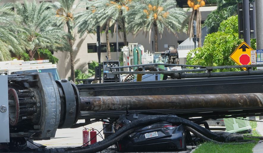 A large construction crane collapsed and crushed a car on Monday, Sept. 14, 2026, in Miami. (AP Photo/Marta Lavandier)