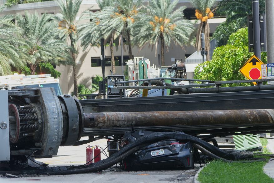 A large construction crane collapsed and crushed a car on Monday, Sept. 14, 2026, in Miami. (AP Photo/Marta Lavandier)