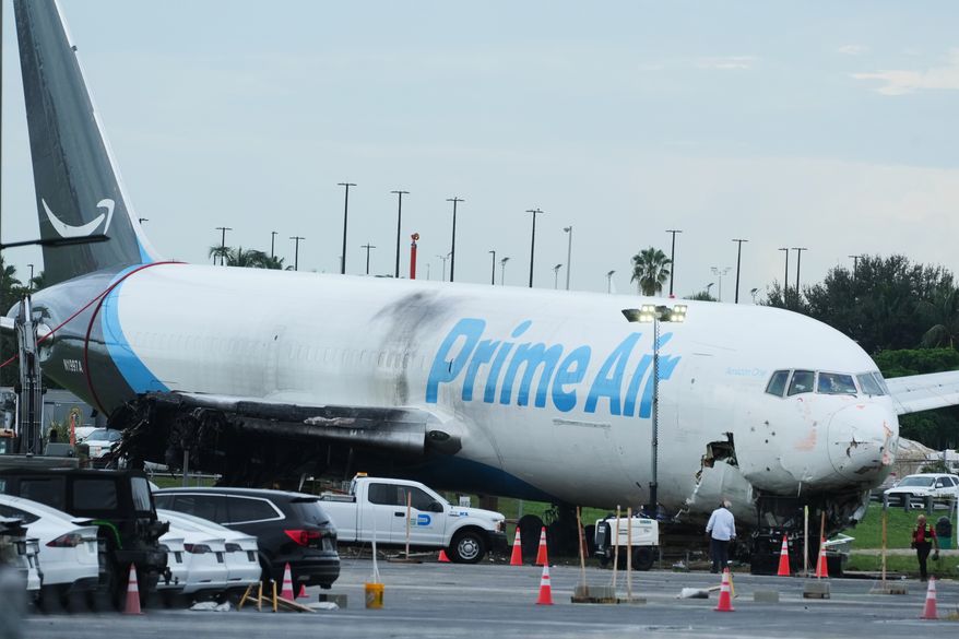 Workers inspect an Amazon cargo plane that overshot a runway four days ago at Miami International Airport, Thursday, Sept. 10, 2026, in Miami. (AP Photo/Marta Lavandier)