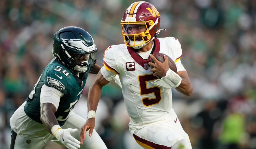 Washington Commanders quarterback Jayden Daniels (5) scramble past Philadelphia Eagles linebacker Keyshawn James-Newby (50) during the second half of an NFL football game, Sunday, Sept. 13, 2026, in Philadelphia. (AP Photo/Matt Slocum)