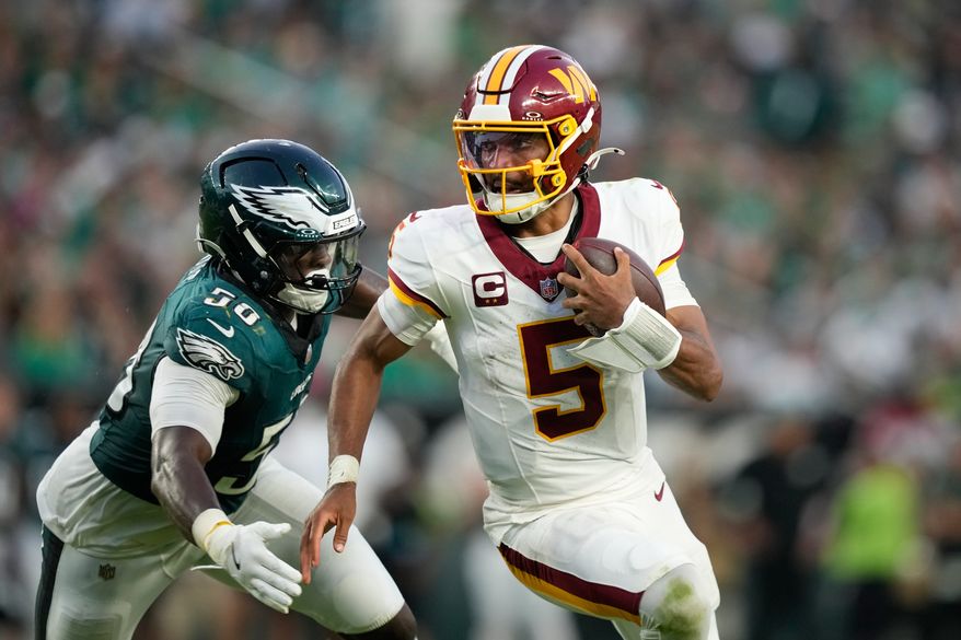Washington Commanders quarterback Jayden Daniels (5) scramble past Philadelphia Eagles linebacker Keyshawn James-Newby (50) during the second half of an NFL football game, Sunday, Sept. 13, 2026, in Philadelphia. (AP Photo/Matt Slocum)