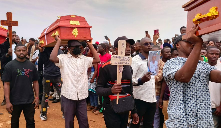 People attend a burial ceremony for school children who died in a fire that swept through two schools in the city of Bukavu, eastern Congo, Monday, Sept. 14, 2026. (AP Photo/Janvier Barhahiga)