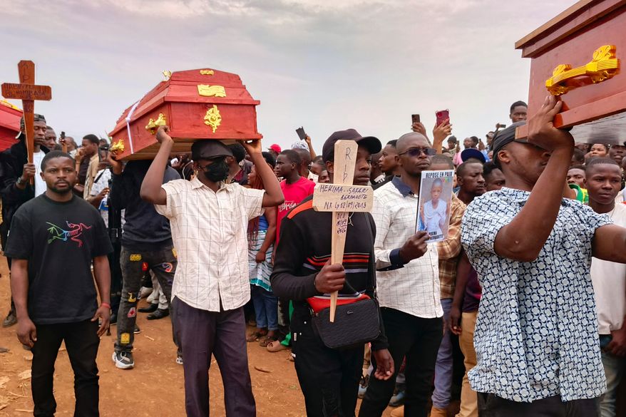 People attend a burial ceremony for school children who died in a fire that swept through two schools in the city of Bukavu, eastern Congo, Monday, Sept. 14, 2026. (AP Photo/Janvier Barhahiga)