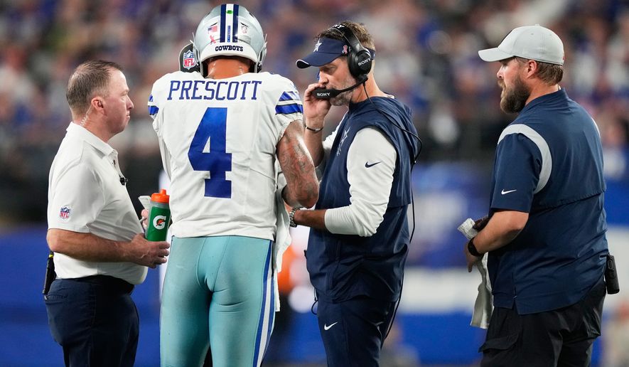 Dallas Cowboys quarterback Dak Prescott (4) talks to head coach Brian Schottenheimer during the first half of an NFL football game against the New York Giants, Sunday, Sept. 13, 2026, in East Rutherford, N.J. (AP Photo/Yuki Iwamura)