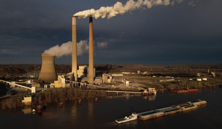 FILE - A barge on the Ohio River moves past the Mountaineer Power Plant, a coal-fired power plant near New Haven, W.Va., March 13, 2026. (AP Photo/Carolyn Kaster, File)