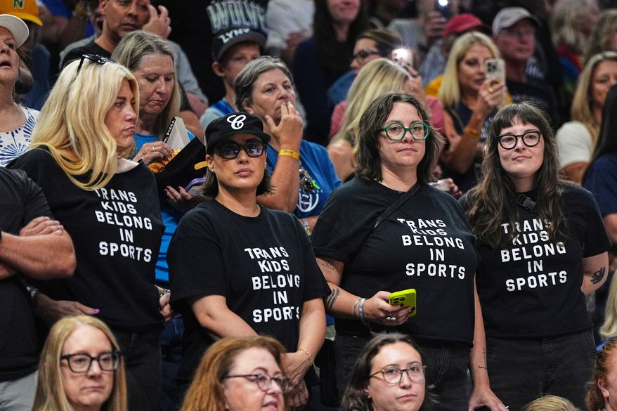 Fans wear shirts saying, "Trans Kids Belong In Sports," during a WNBA basketball game between the Minnesota Lynx and the Indiana Fever, Aug. 2, 2026, in Minneapolis. (AP Photo/Abbie Parr)