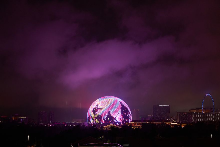 Lights from the Sphere illuminate rain clouds above The Strip, Nov. 15, 2025, in Las Vegas. (AP Photo/John Locher, File)
