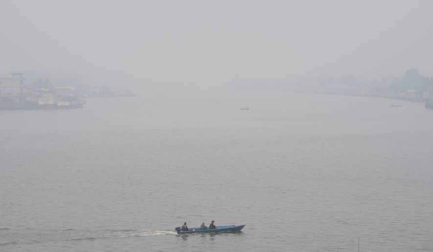 A boat cruises on Kapuas River amid the thick haze from forest fires, in Pontianak, West Kalimantan, Indonesia, Monday, Sept. 14, 2026. (AP Photo/Tatan Syuflana)