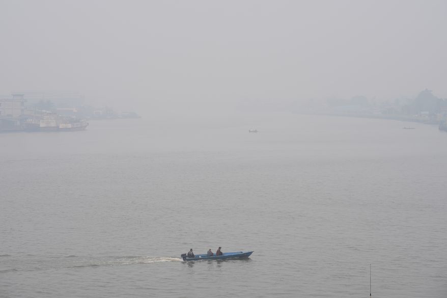 A boat cruises on Kapuas River amid the thick haze from forest fires, in Pontianak, West Kalimantan, Indonesia, Monday, Sept. 14, 2026. (AP Photo/Tatan Syuflana)