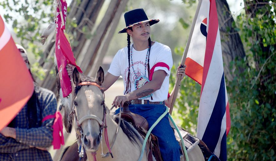 Kolten Lawrence protests near the Foundations for Nations church in Arapahoe, Wyo., on Sunday, Aug. 16, 2026. (AP Photo/Thomas Peipert)