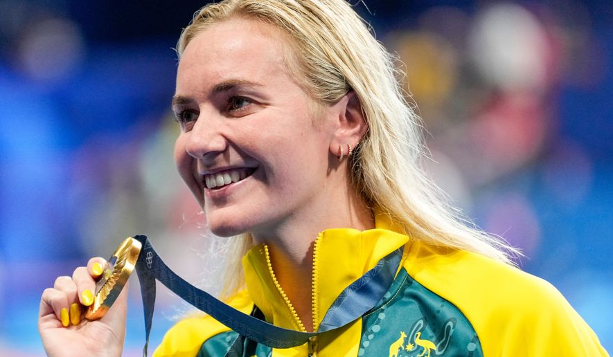 Australia's Ariarne Titmus poses with her gold medal after winning the women's 400-meter freestyle final at the 2024 Summer Olympics, July 27, 2024, in Nanterre, France. (AP Photo/Ashley Landis, File)