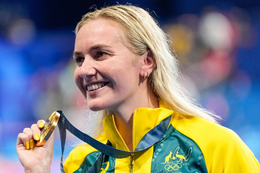 Australia's Ariarne Titmus poses with her gold medal after winning the women's 400-meter freestyle final at the 2024 Summer Olympics, July 27, 2024, in Nanterre, France. (AP Photo/Ashley Landis, File)