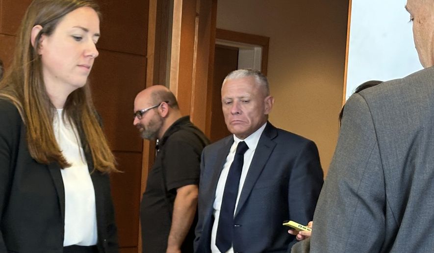 This photo taken with a smartphone shows defense attorney Delia McCarthy, left, and Jeffrey Buskey, center, charged with multiple counts of aggravated felonious sexual assault, leaving a courtroom during a break in Buskey's trial in Manchester, N.H., Monday, Sept. 14, 2026. (AP Photo/Holly Ramer)
