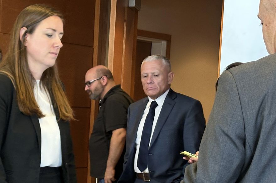 This photo taken with a smartphone shows defense attorney Delia McCarthy, left, and Jeffrey Buskey, center, charged with multiple counts of aggravated felonious sexual assault, leaving a courtroom during a break in Buskey's trial in Manchester, N.H., Monday, Sept. 14, 2026. (AP Photo/Holly Ramer)