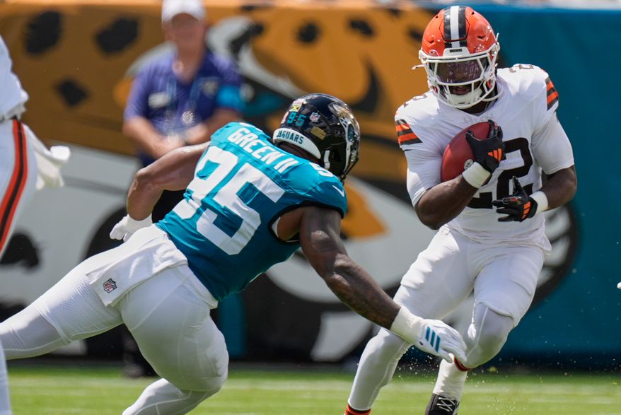 Cleveland Browns running back Dylan Sampson (22) carries against Jacksonville Jaguars defensive end B.J. Green II (95) in the first half of an NFL football game, Sunday, Sept. 13, 2026, in Jacksonville. (AP Photo/Mike Stewart)