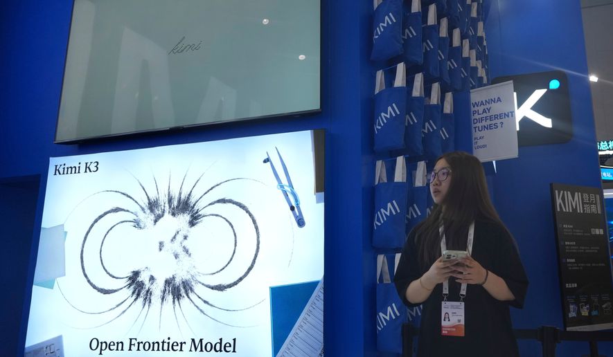 A worker stands at the booth for Chinese AI Startup Moonshot's Kimi K3 during the World AI Conference in Shanghai, China on July 17, 2026. (AP Photo/Ng Han Guan, File)