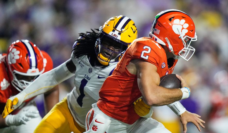 Clemson quarterback Tait Reynolds (2) is sacked by LSU defensive end Princewill Umanmielen (1) in the first half of an NCAA college football game, Saturday, Sept. 5, 2026 in Baton Rouge, La. (AP Photo/Gerald Herbert)