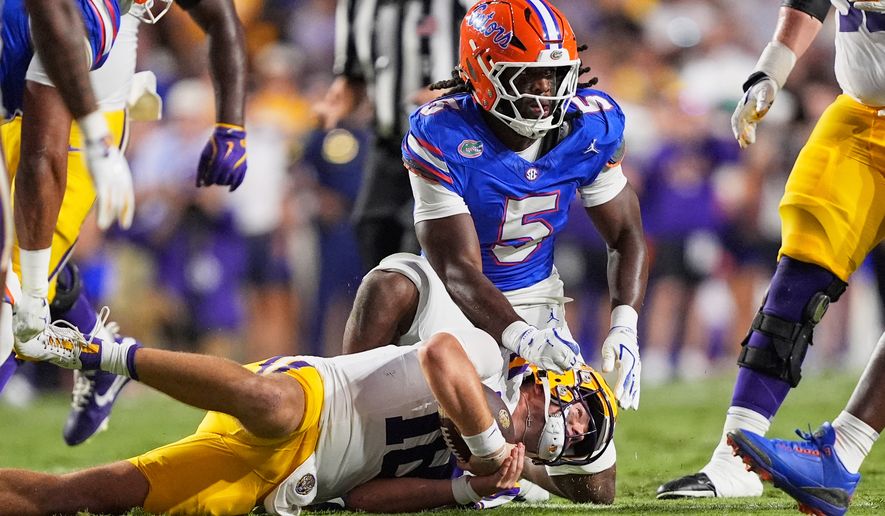 FILE - Florida linebacker Myles Graham (5) tackles LSU quarterback Garrett Nussmeier in the first half of an NCAA college football game, Sept. 13, 2025, in Baton Rouge, La. (AP Photo/Gerald Herbert, File)
