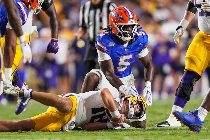 FILE - Florida linebacker Myles Graham (5) tackles LSU quarterback Garrett Nussmeier in the first half of an NCAA college football game, Sept. 13, 2025, in Baton Rouge, La. (AP Photo/Gerald Herbert, File)