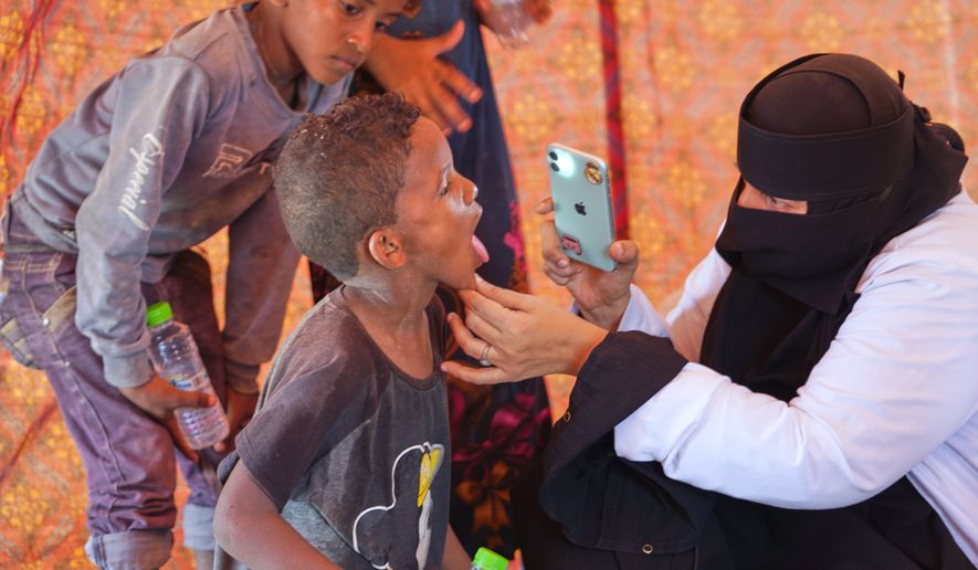 A doctor examines a displaced child at Al-Firdaws camp in Ras Imran, just outside Aden, Yemen, Monday, Sept. 14, 2026. (AP Photo/Abdulnasser Alseddik)